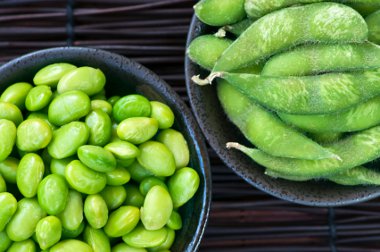 Edamame soy beans shelled and with pods in bowls