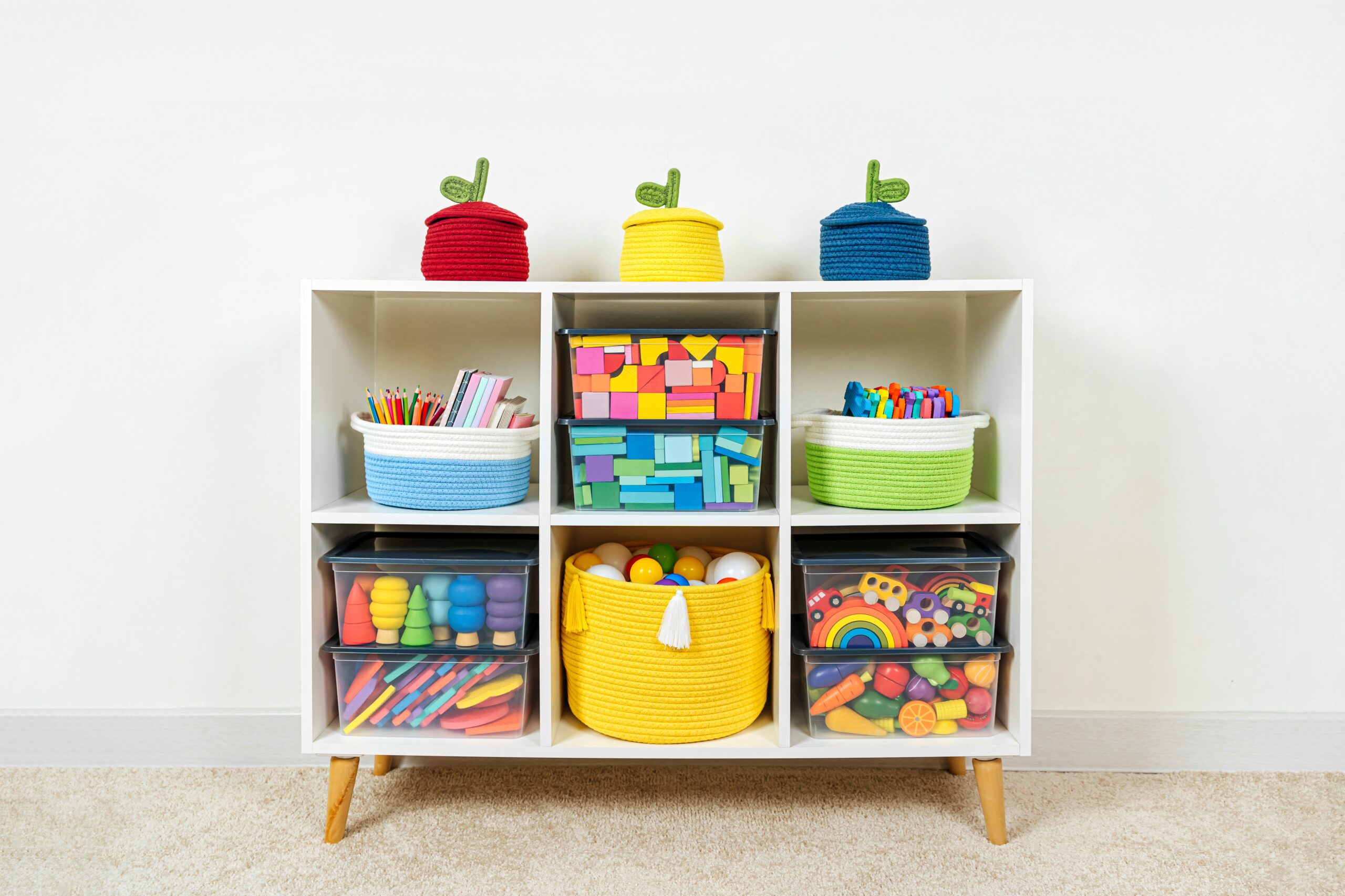 White shelving with rainbow wooden toys and colorful storage baskets and boxes