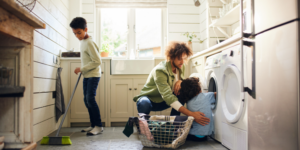 Father and 2 sons help each other clean up a laundry room