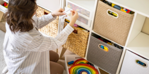 Woman puts label on organizational cubes while putting children's toys away